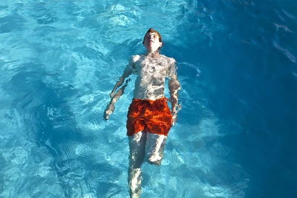幸せな少年は、屋外プールで泳いでいます。 — ストック写真