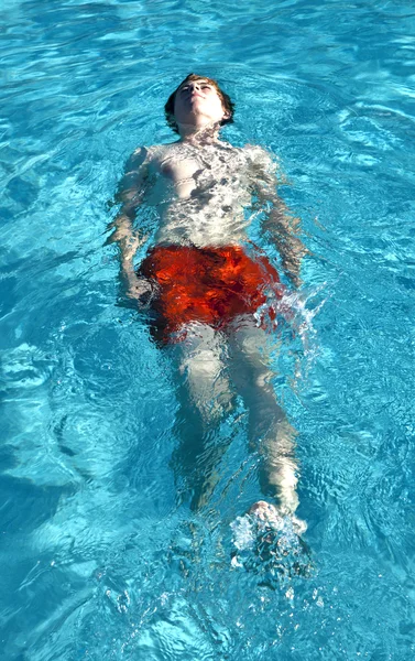 Felice ragazzo sta nuotando nella piscina all'aperto — Foto Stock