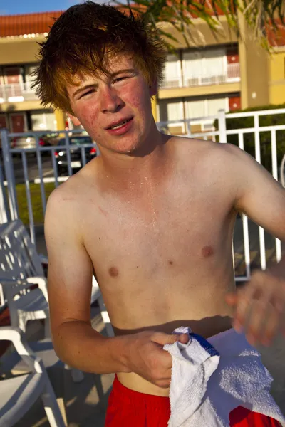 Jongen met een handdoek na het zwemmen in een pool — Stockfoto