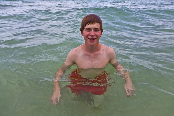 Genç adam okyanusta yüzüyor — Stok fotoğraf