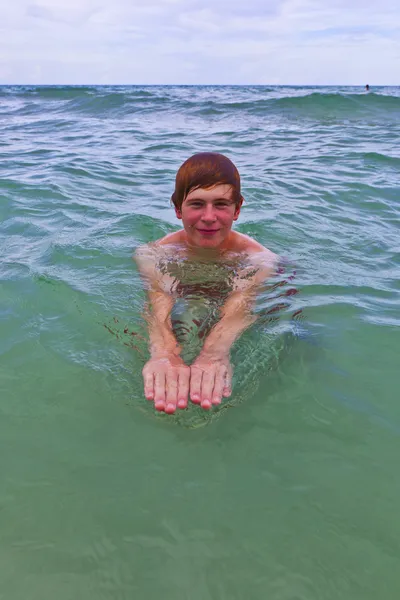 若い男は、海で泳いでいます。 — ストック写真