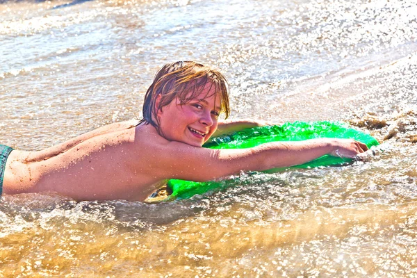 Boy has fun with the surfboard Stock Picture