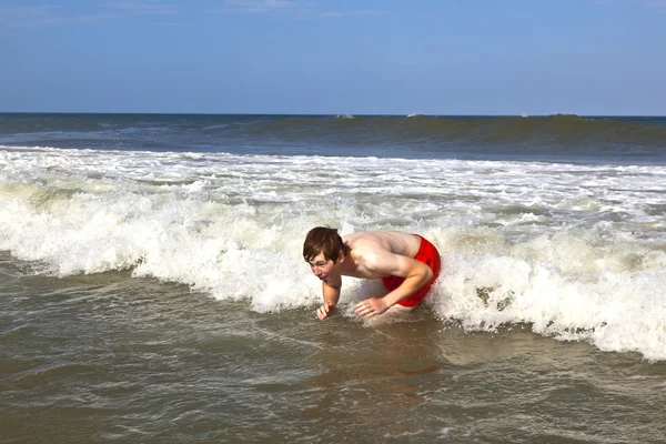 Young boy is body surfing in the waves of the ocean Royalty Free Stock Photos