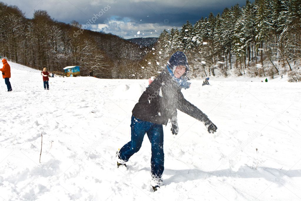 Children have a snowball fight in the white snowy area