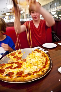 Smiling boy in a diners at night clipart