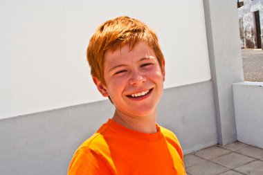 Kahverengi gözlü sevimli çocuk gülümsüyor.