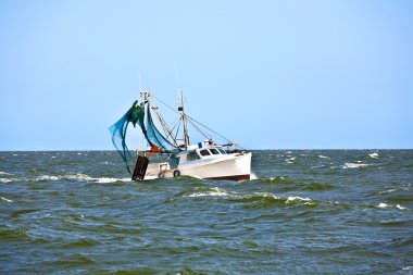 Small fishing boat heading out to the ocean clipart