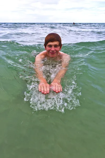 Mladý muž je plavání v oceánu — Stock fotografie