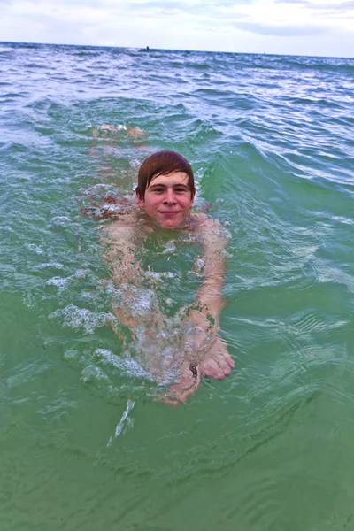 Молодой человек плавает в океане — стоковое фото