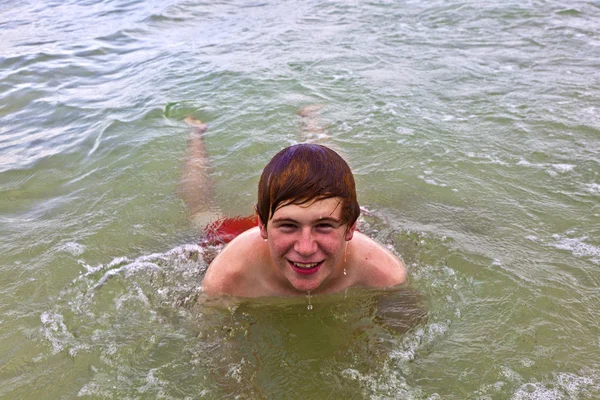 Joven está nadando en el océano —  Fotos de Stock