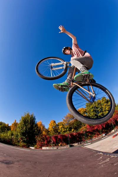 Menino indo no ar com sua bicicleta de sujeira — Fotografia de Stock
