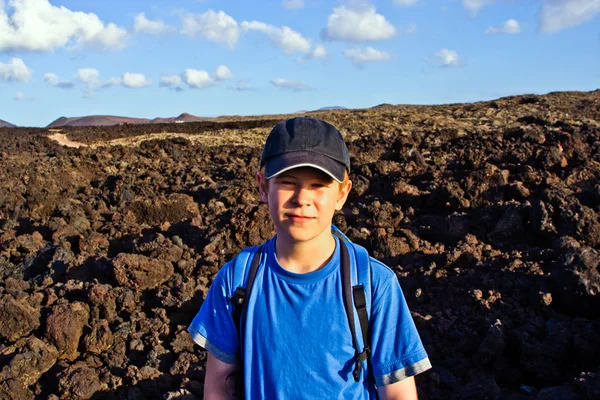 Giovane ragazzo a piedi attraverso l'area vulcanica di Lanzarote — Foto Stock