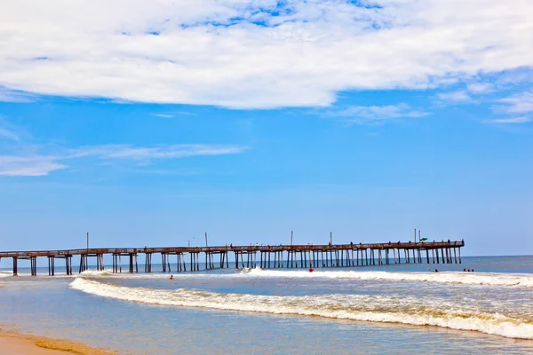 Strand met oude houten pier — Stockfoto