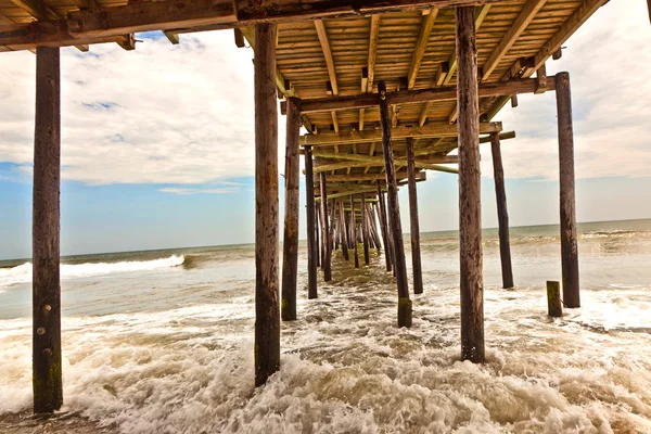Strand met oude houten pier — Stockfoto