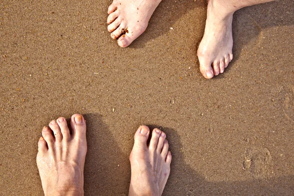 Pés de um casal na praia — Fotografia de Stock