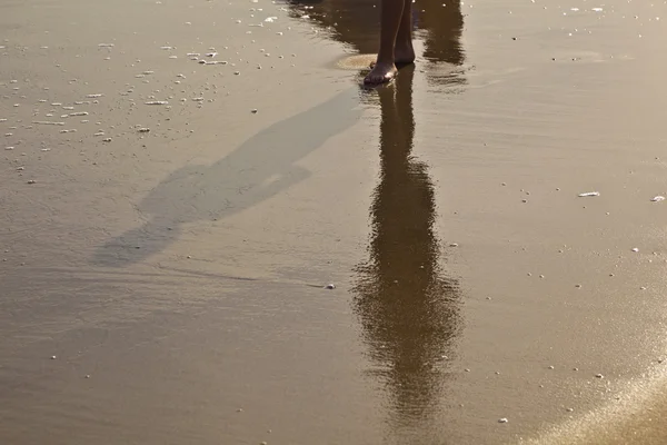 Fötter av pojke löper längs stranden — Stockfoto