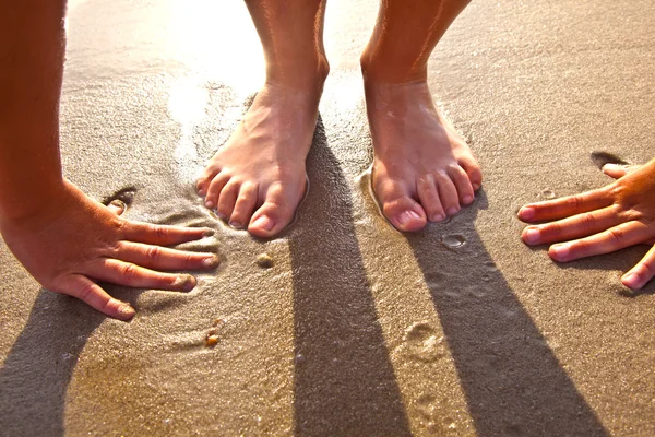 Pés de menino na areia molhada na praia — Fotografia de Stock