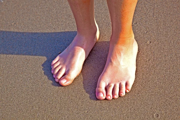 Ноги мальчика на мокром песке на пляже — стоковое фото
