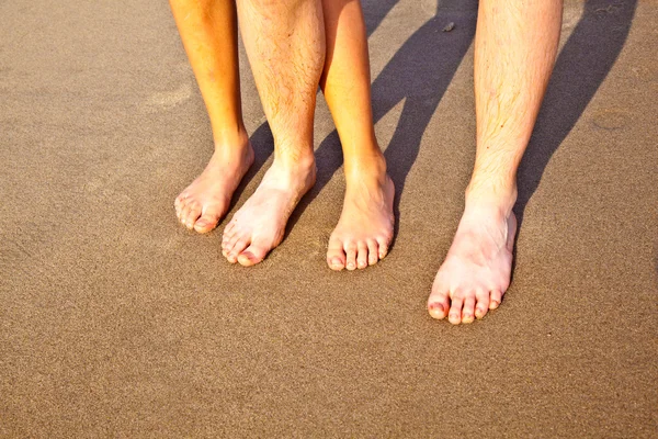 Pies de padre e hijo en la arena mojada de la playa —  Fotos de Stock