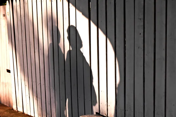 Σκιά του ένα αγόρι με μητέρα σε έναν ξύλινο φράκτη — Φωτογραφία Αρχείου