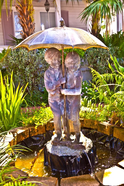 Fonte com água de um guarda-chuva com crianças — Fotografia de Stock