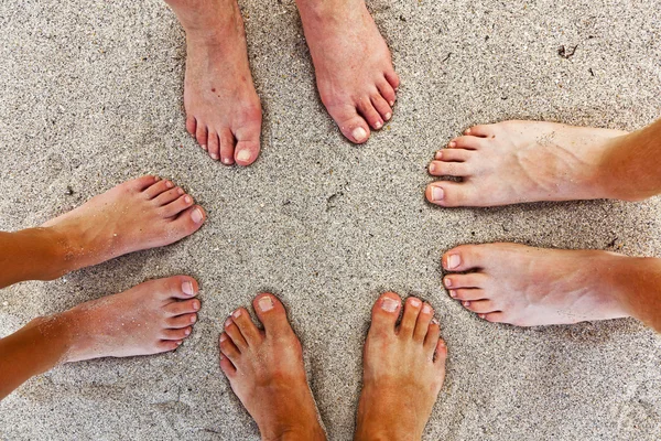 Fötter av familjen på stranden — Stockfoto