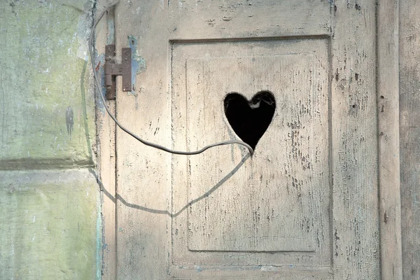 Старая деревянная дверь с резным романтическим сердцем — стоковое фото