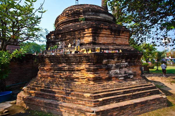Souvenirs, kleine Buddhas werden auf den Fuß eines Chedi gelegt — Stockfoto