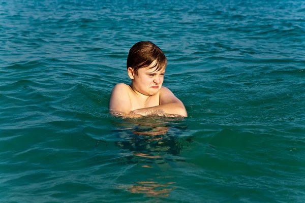 Chłopiec przeżywa jasne ciepłej wody przy pięknej plaży, ale — Zdjęcie stockowe