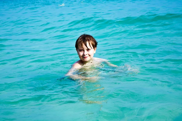 Garoto sorridente gosta de nadar no mar — Fotografia de Stock