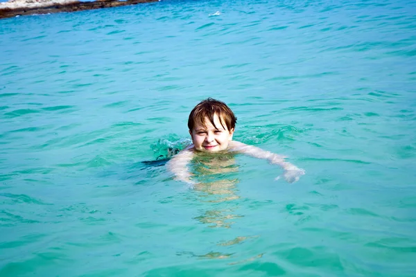Joven niño feliz con el pelo castaño disfruta nadando en la hermosa —  Fotos de Stock