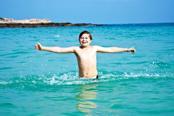 Chico está disfrutando del agua caliente clara en la hermosa playa, pero —  Fotos de Stock
