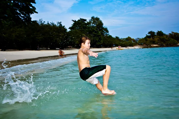 stock image Boy is enjoying the clear warm water at the beautiful beach but