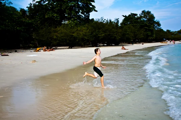 男孩很享受在美丽的海滩清晰温暖的水，但 — 图库照片