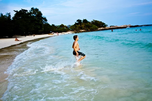 Ragazzo sta godendo l'acqua calda e limpida alla bella spiaggia, ma — Foto Stock
