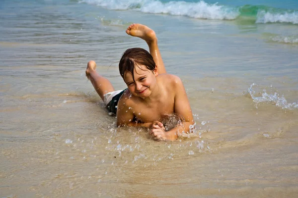 Мальчик лежит на пляже и наслаждается теплом — стоковое фото