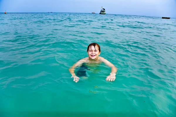 Niño está nadando en el mar cálido y claro y disfrutando de la aspiradora —  Fotos de Stock