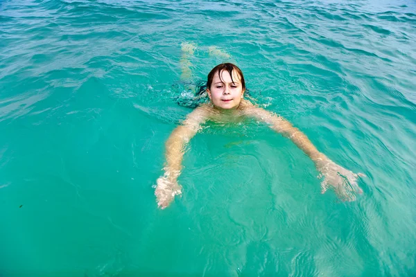 Jovem está nadando no mar quente e claro e desfrutando do vac — Fotografia de Stock