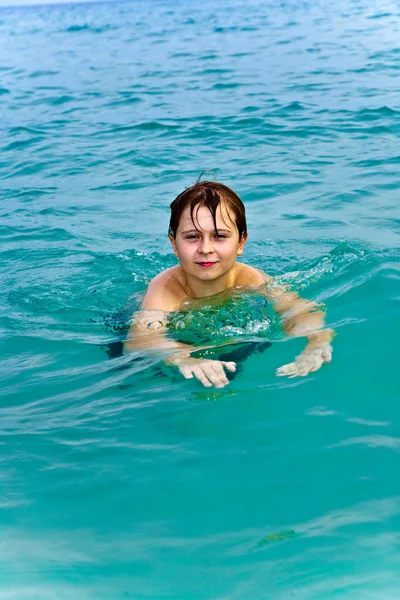 Ung pojke bad i det varma klara havet och njuta av vac — Stockfoto