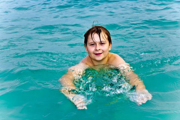 Jonge jongen is zwemmen in de warme, heldere zee en genieten van de ABV-waarde — Stockfoto