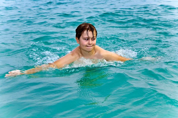 Young boy is swimming in the warm clear sea and enjoying the vac — Stock Photo, Image