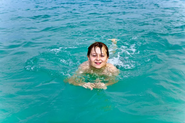 Młody chłopak jest pływanie w morzu jasne, ciepłe i korzystających z vac — Zdjęcie stockowe