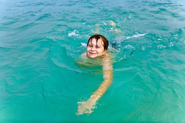 年轻的男孩是在温暖的明确海中游泳，享受 vac — 图库照片