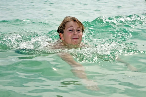 Jovem menino feliz com cabelo castanho gosta de nadar na bela — Fotografia de Stock