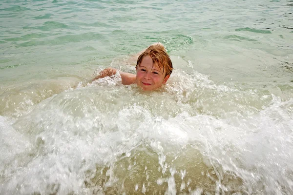 Joven niño feliz con el pelo castaño disfruta nadando en la hermosa —  Fotos de Stock