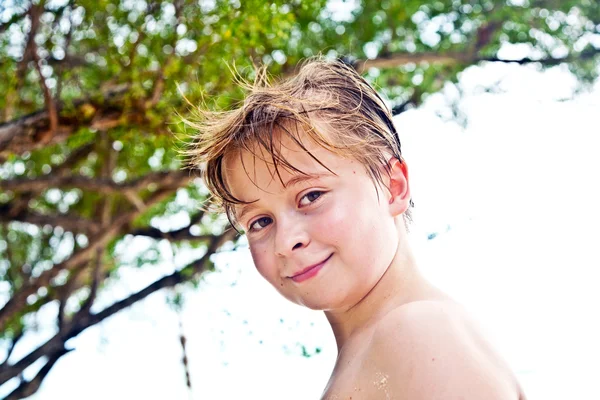 Young boy at the beach is smiling and looking self confident — Stock Photo, Image