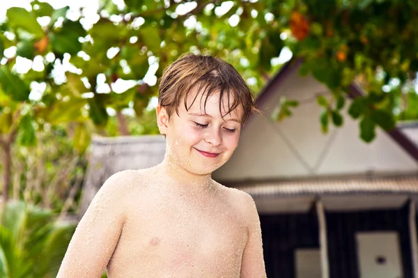 Мальчик на пляже улыбается и выглядит уверенным в себе — стоковое фото