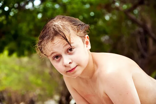 Νεαρό αγόρι με βρεγμένα μαλλιά βγαίνει από την θάλασσα χαμογελά και φαίνεται — Φωτογραφία Αρχείου