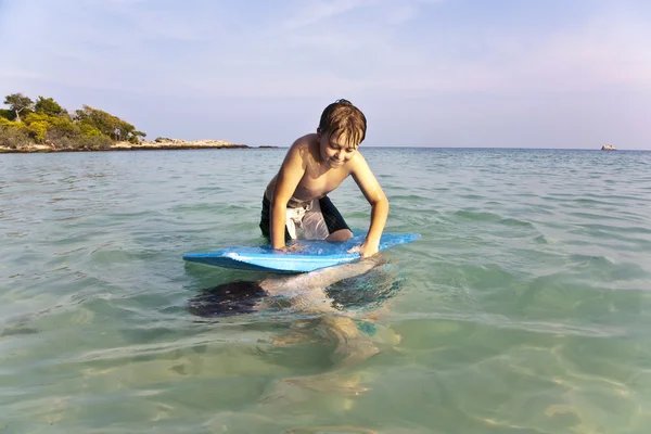 Chłopiec surfing w morzu — Zdjęcie stockowe