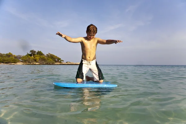 Chłopiec surfing w morzu — Zdjęcie stockowe